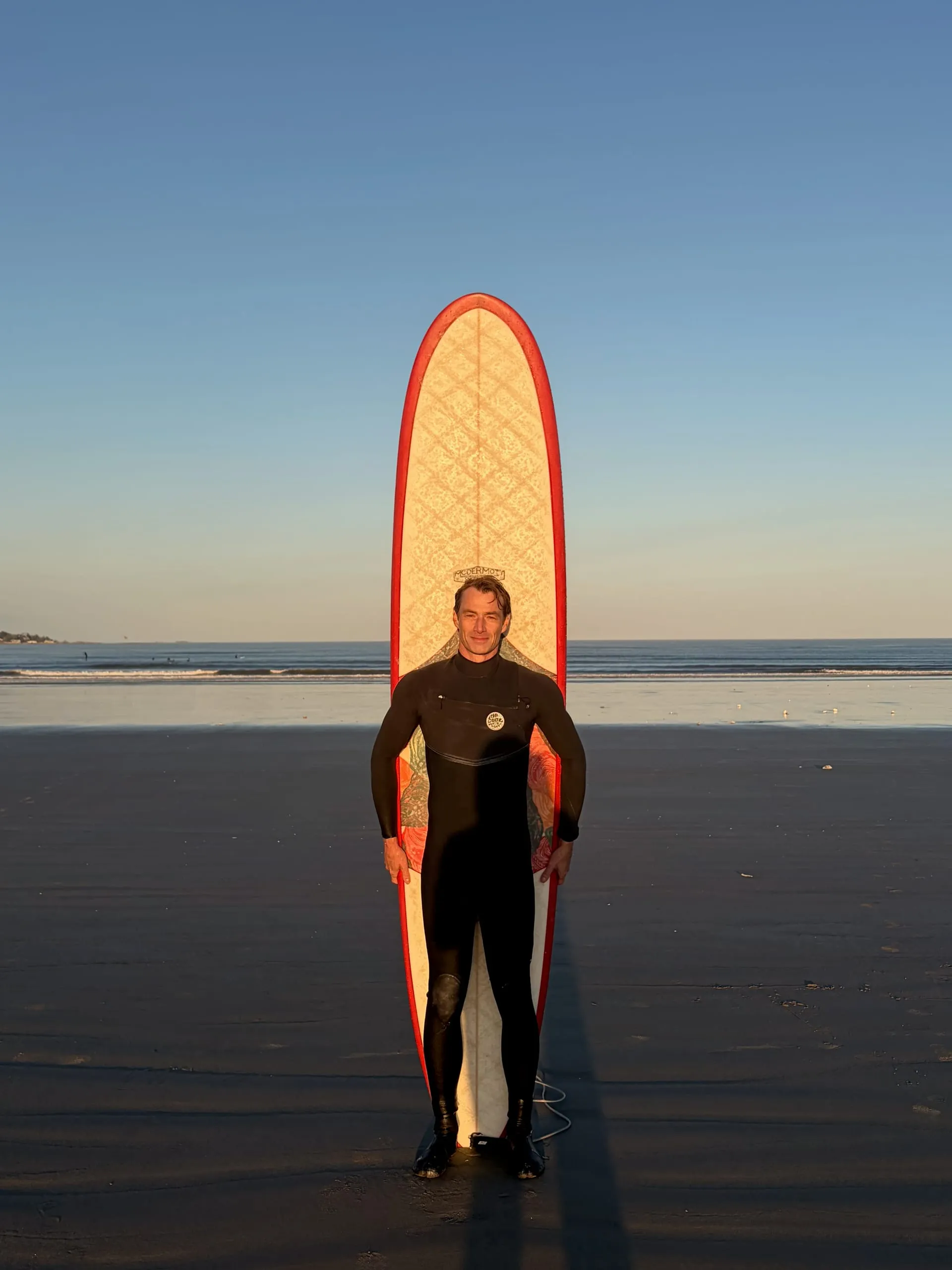 Surfer with longboard standing at Nahant beach